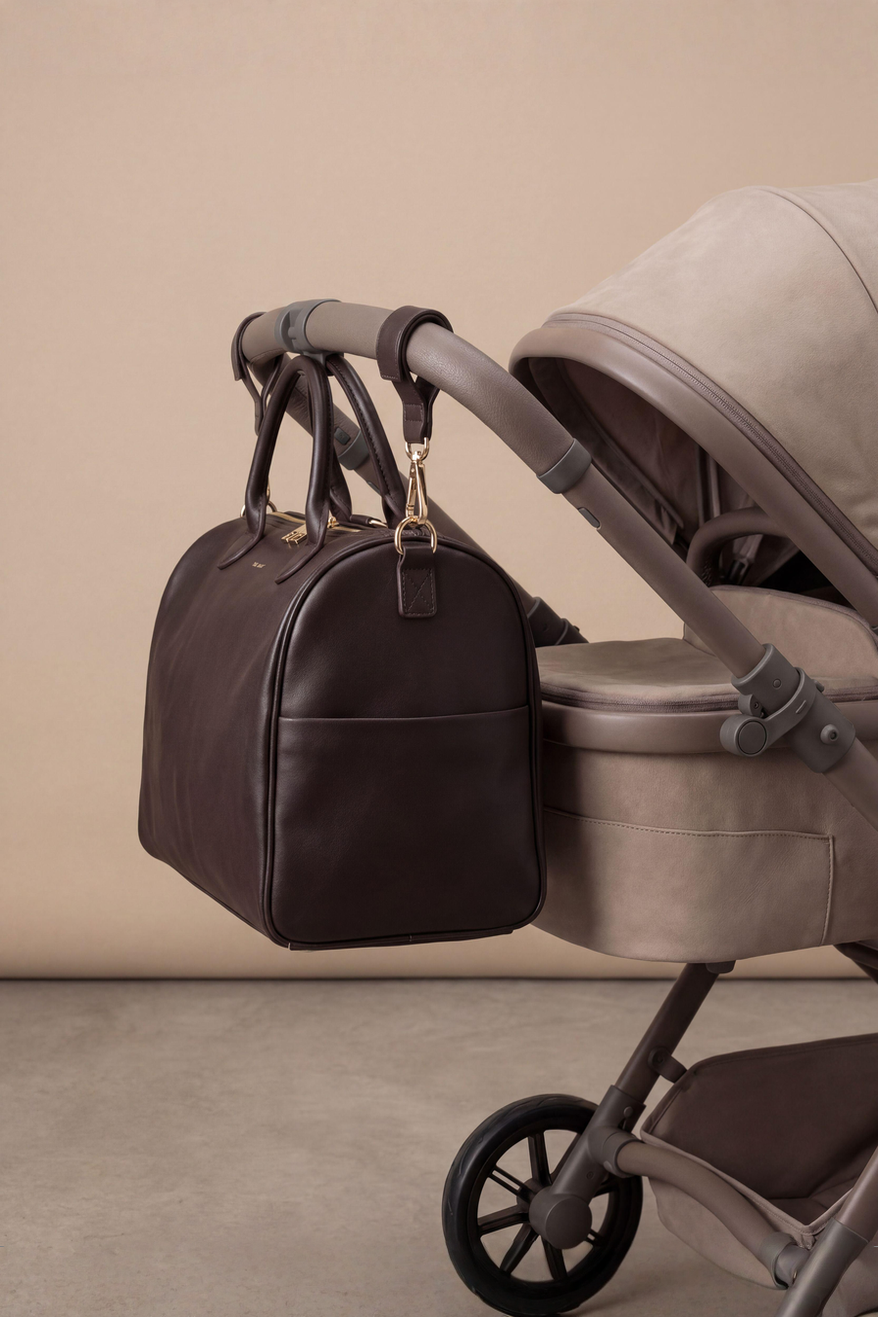 The Mosi Espresso luxe luiertas bevestigd aan een kinderwagen