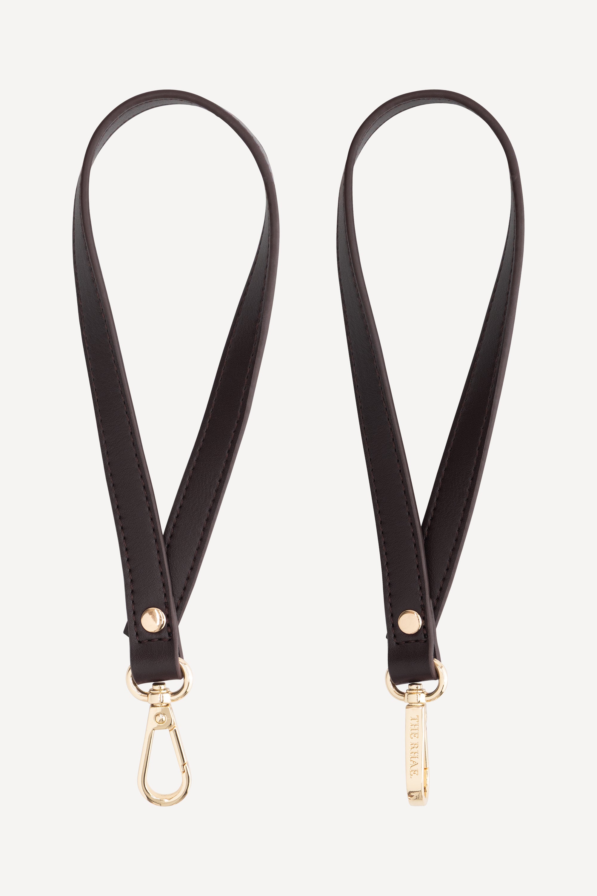 The Rhae Stroller Straps Espresso van premium vegan leer met goudkleurige clips voor de kinderwagen