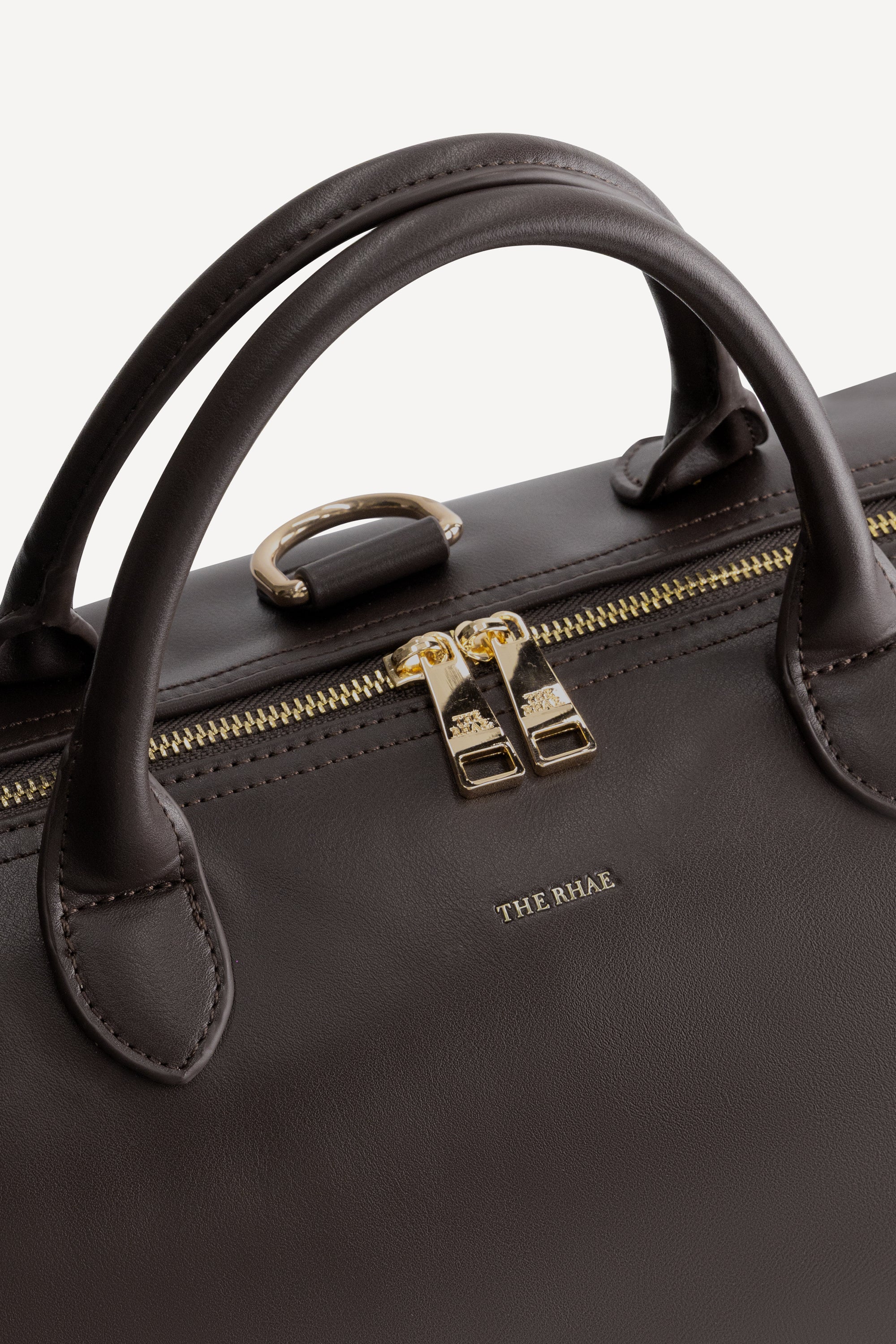 Detail van The Mosi Espresso luxe luiertas met vegan leren handgrepen en goudkleurige ritssluiting