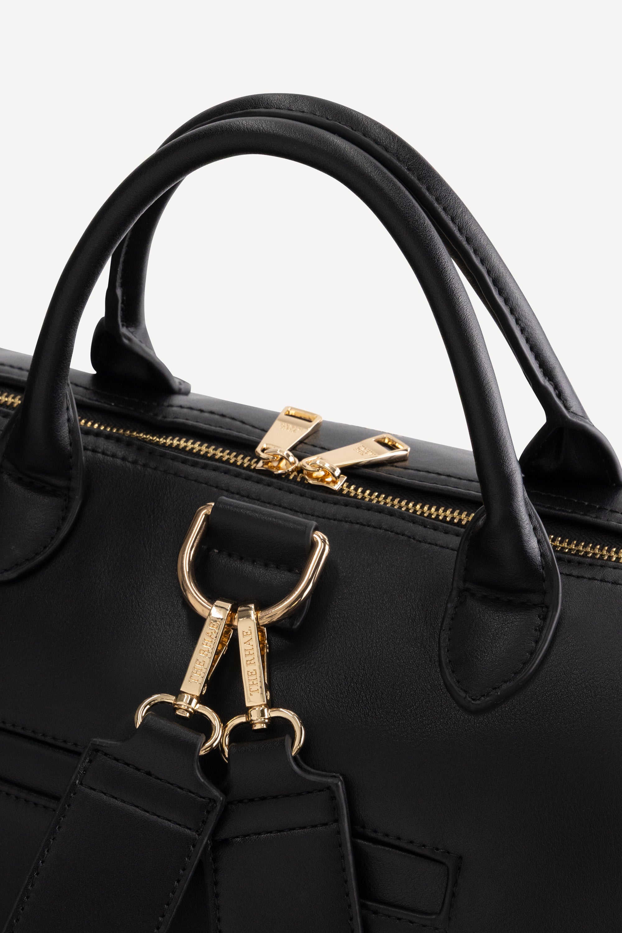 Detail van de handgrepen, rits en goudkleurige hardware van The Mosi Black luiertas
