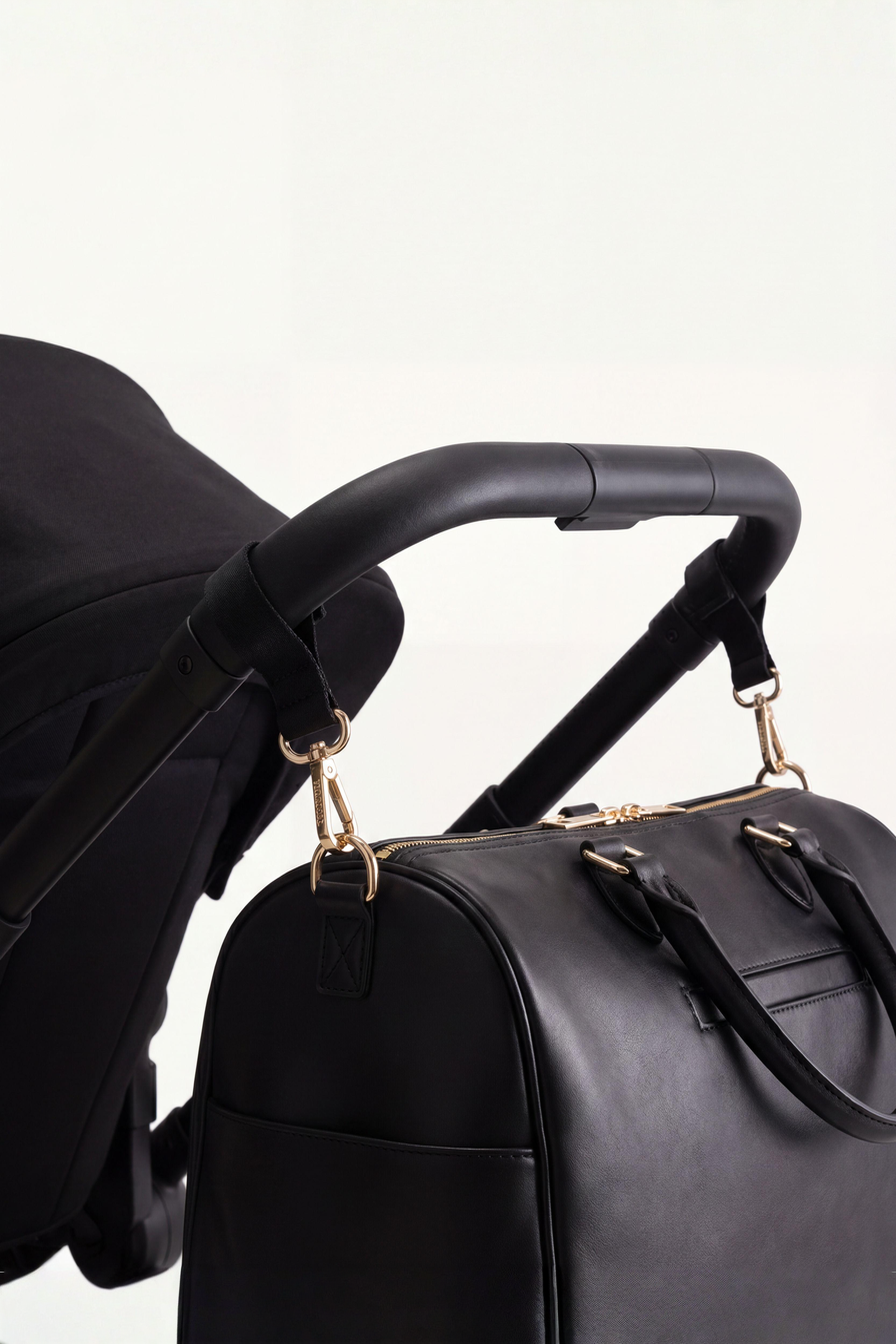 The Mosi Black luiertas bevestigd aan een kinderwagen.